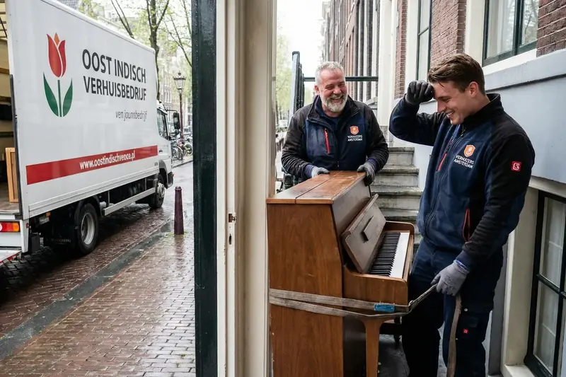 Piano wordt door een smalle doorgang in Amsterdam verhuisd